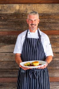 The Boat Shed Chef Holding Dinner Plate